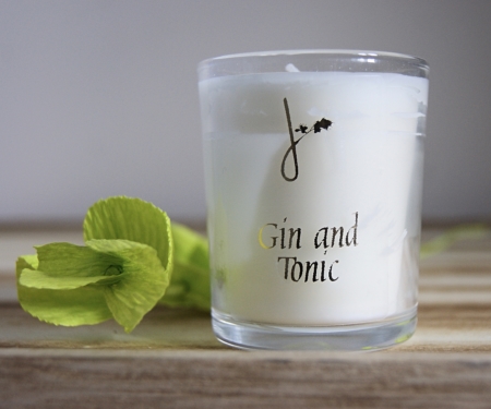 gin and tonic fragrance candle by home of juniper next to paperbea foliage