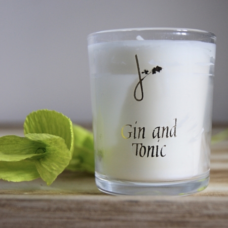gin and tonic fragrance candle by home of juniper next to paperbea foliage