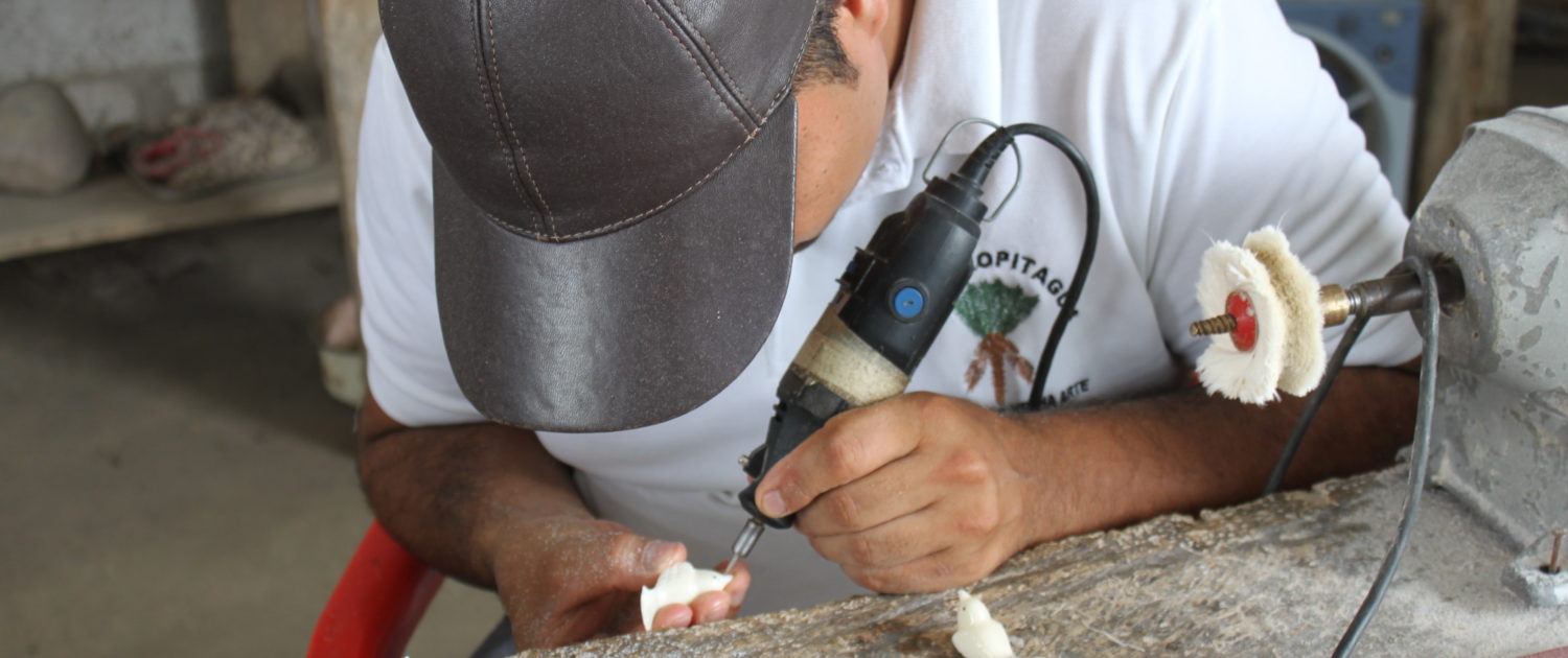 Man making jewellery charm from Tagua nut